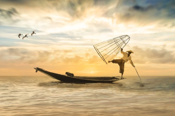 Fisherman balancing on boat