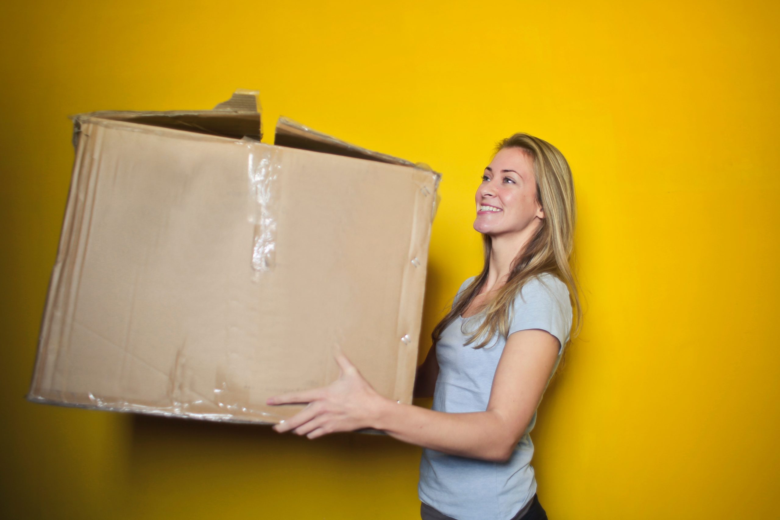 Woman Holding Cardboard Box - Start a Courier Service with VirtualPBX