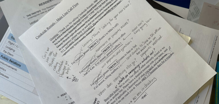 Alt Text: A printed customer service call flow document for Creekside Rentals on a messy desk, covered in handwritten notes identifying routing problems and unmonitored voicemail traps.